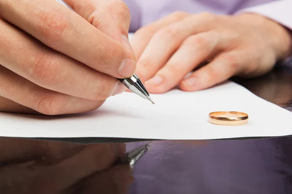 Nahaufnahme einer männlichen Hand, die Scheidungspapiere unterschreibt — Stockfoto