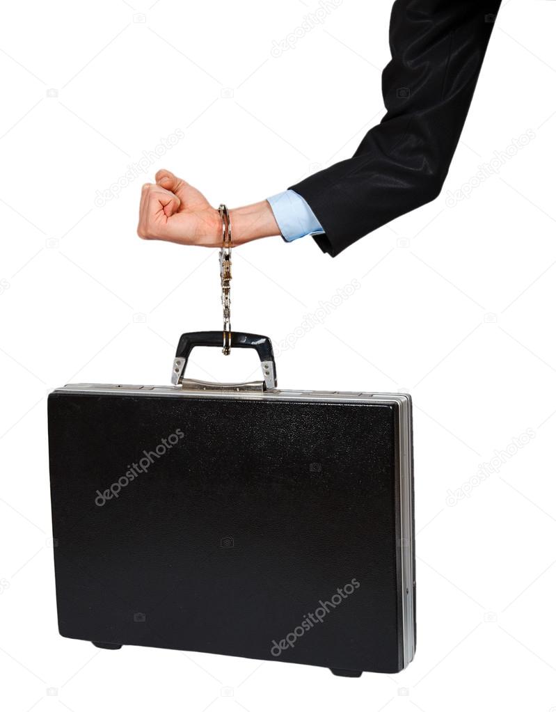 Hand in black suit with handcuffs chained to the black case