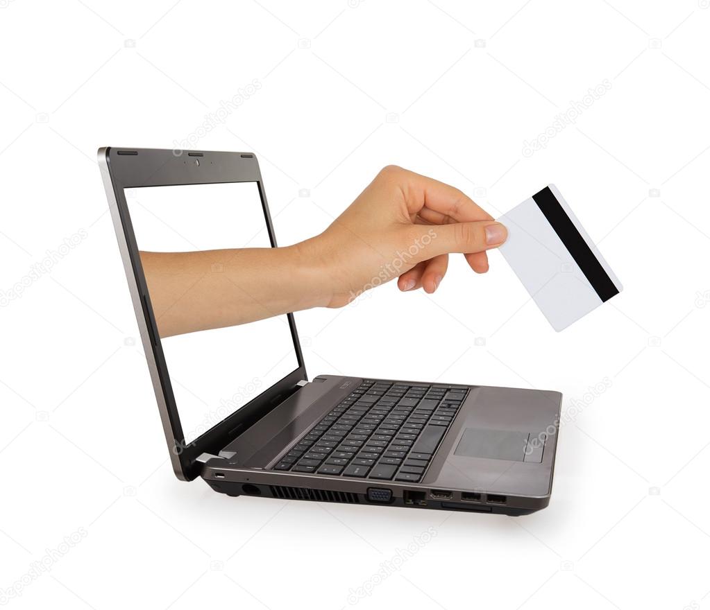 Hand with credit card comes from laptop screen
