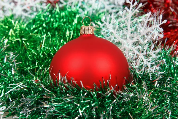 Christmas röd boll med girlander och vita snöflingor — Stockfoto