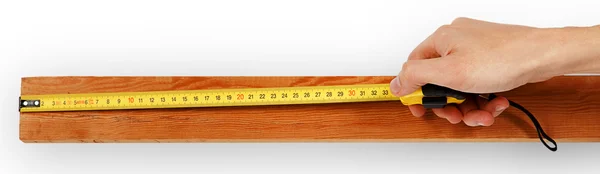 Close-up of a male hand using measuring tape on wooden board — Stock Photo, Image