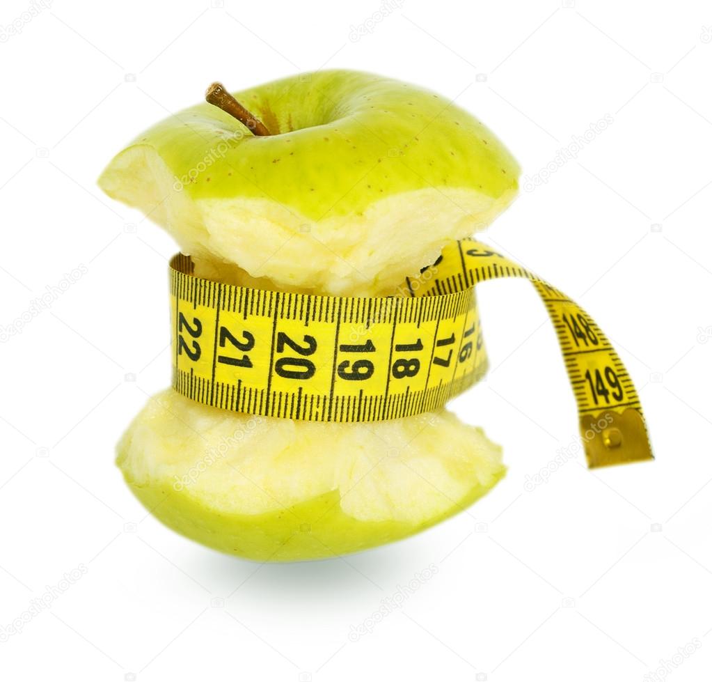 Green apple core and yellow measuring tape
