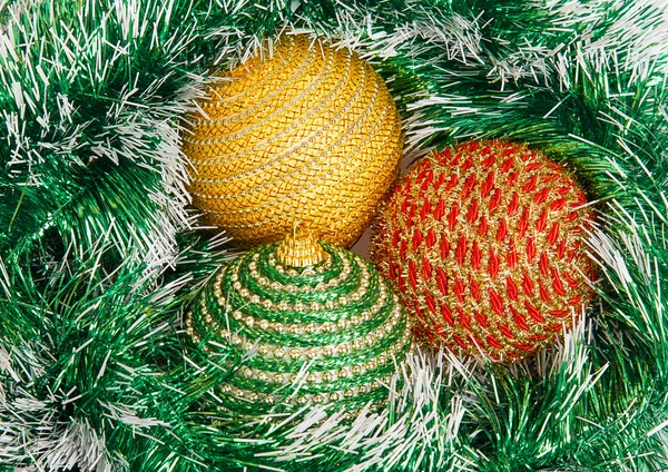 Drei Weihnachtskugeln auf grünem Kranz — Stockfoto