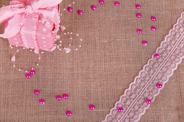 Background of burlap with pink git box and pink lace — Stock Photo, Image