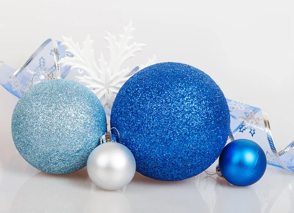 Bolas azules de Navidad con copos de nieve blancos y cinta — Foto de Stock