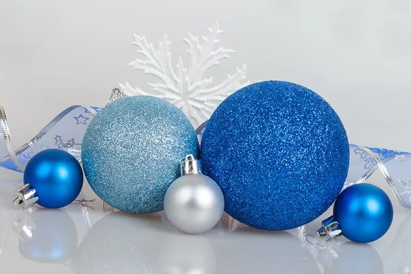 Blauwe kerstballen met witte sneeuwvlokken en lint — Stockfoto