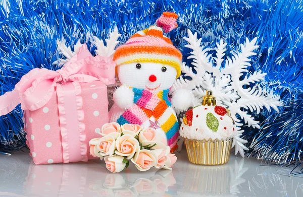 Snögubbe med rosa gåva rutan och vita snöflingor — Stockfoto