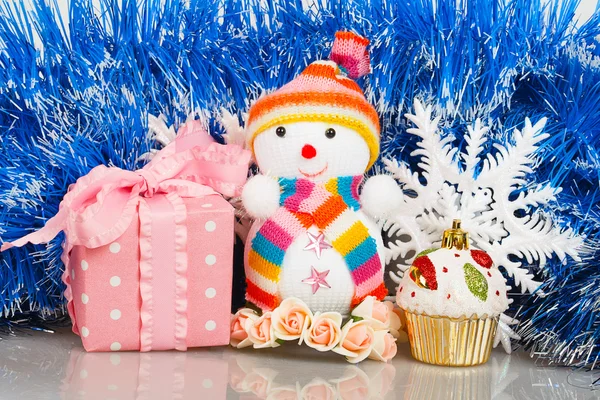 Snögubbe med rosa gåva rutan och vita snöflingor — Stockfoto