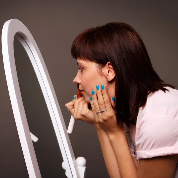 Fiatal nő vonatkozik smink egy nagy tükör előtt — Stock Fotó