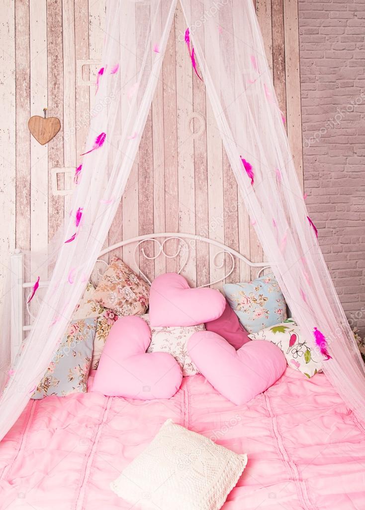 Four-poster bed with pink pillows