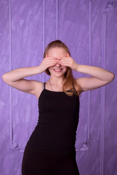 Portret van een jonge vrouw in een zwarte sloot haar ogen met haar hand — Stockfoto