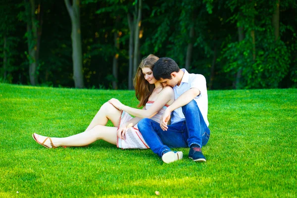 Liefhebbers van man en vrouw zittend op het gras — Stockfoto