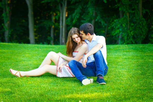 연인 남자와 여 자가 잔디에 앉아 — 스톡 사진