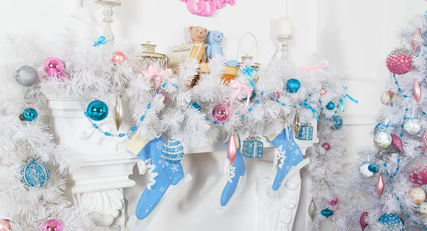 White garland above the fireplace with blue skates and toys — Stock Photo, Image