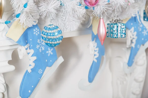 White garland above the fireplace with blue skates and toys — Stock Photo, Image