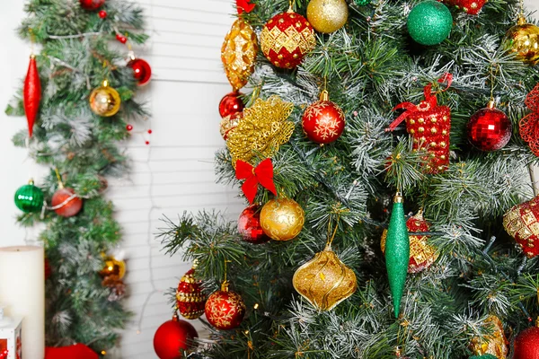 Sapin vert avec jouets de Noël rouges et dorés — Photo