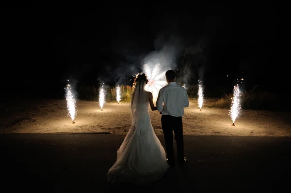 Bride and groom on the background of wedding fireworks — Stock Photo, Image