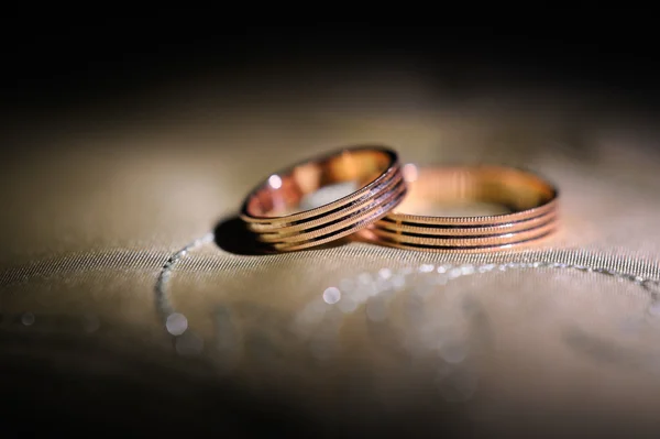 Par de anillos de boda de oro en una almohada — Foto de Stock