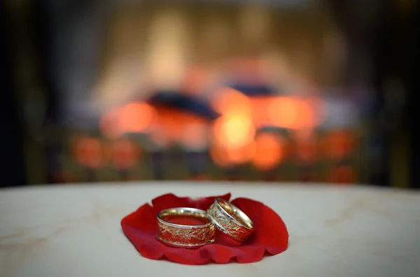 Par de anillos de boda de oro en el pétalo de rosa — Foto de Stock