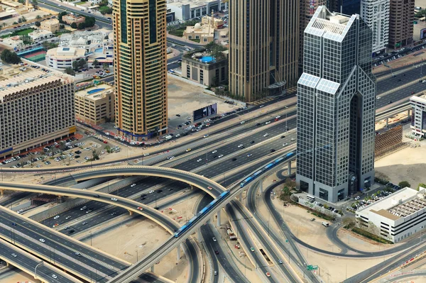 Dos trenes, cruce de carreteras y rascacielos desde arriba en Dubai — Foto de Stock