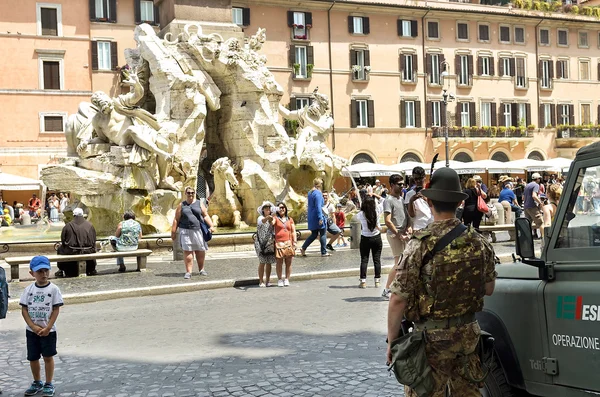 Child looks armed soldiers on patrol in Piazza Navona in Rome. — Stock Photo, Image