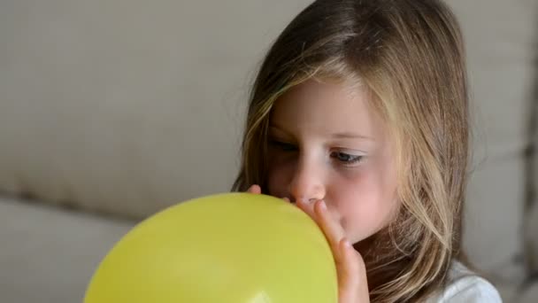 Dziewczyna nadmuchiwanie balonu żółty — Wideo stockowe