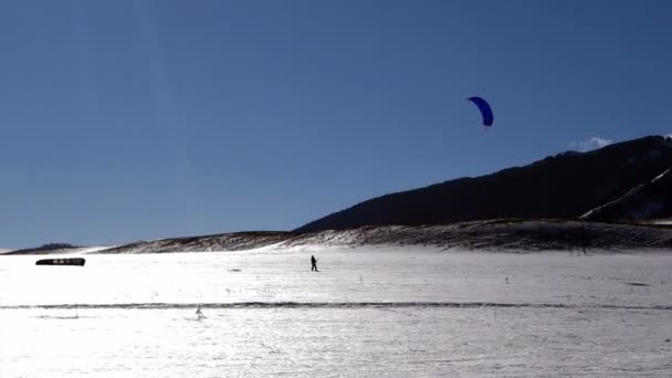 Cours de snowkite dans une vallée enneigée — Video