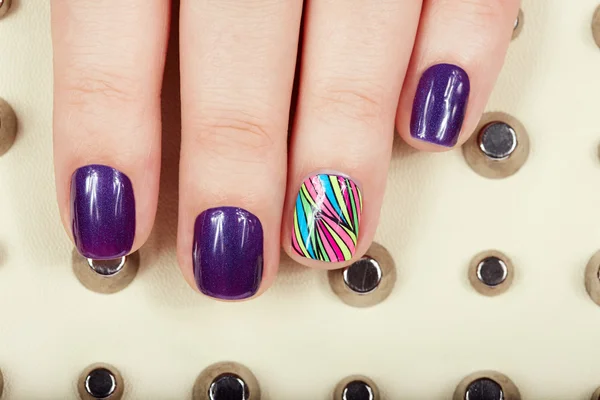 Manicured nails covered with purple nail polish