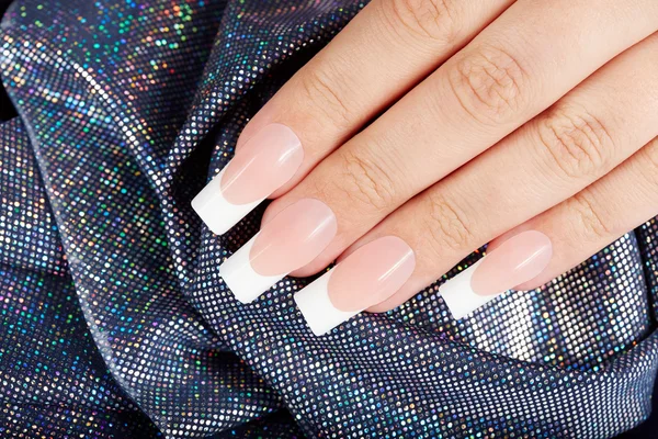 Mão com unhas manicured francesas artificiais longas — Fotografia de Stock