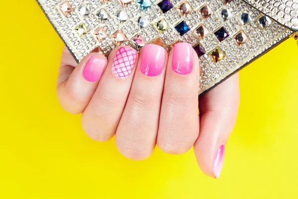 Pregos com manicure coberto com esmalte rosa, fundo amarelo — Fotografia de Stock