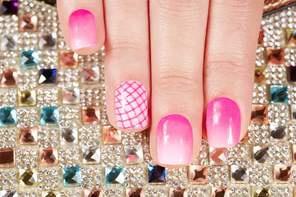Unghie con manicure ricoperte di smalto rosa su fondo di cristalli — Foto Stock