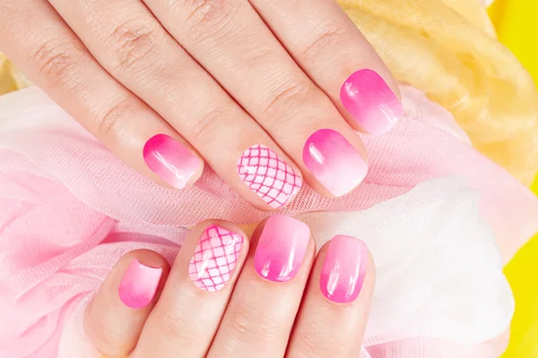 Handen met gemanicuurde nagels bedekt met roze nagellak — Stockfoto