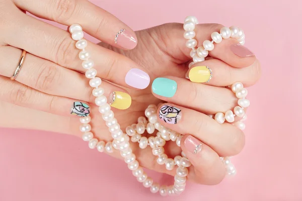 Mãos com belas unhas manicured segurando colar de pérolas — Fotografia de Stock