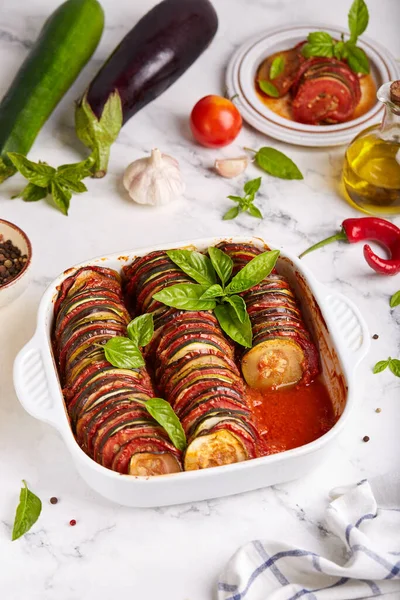 Ratatouille. Stewed vegetable dish with eggplant, zucchini and tomatoes served with basil leaves. Vegetarian dish.