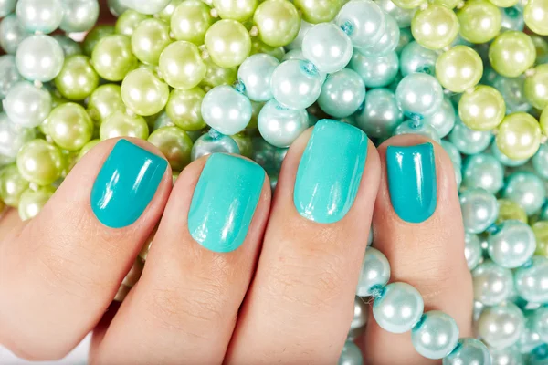 Clavos con manicura sobre fondo de perlas de colores — Foto de Stock