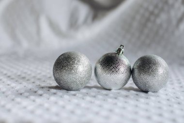 Topun şeklindeki üç parlak Noel ağacı oyuncağı, gümüş rengi beyaz arka planda beyaz bir arkaplanda metin için bir boşluk ile sıralanır. Noel ve Yeni Yıl kavramı