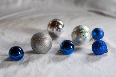 Parlak ve mavi Noel balonları ve beyaz arka planda bir çelenk..