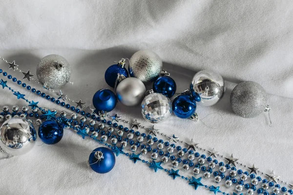 Рождественские бусины в голубом и серебристом на белом фоне. — стоковое фото