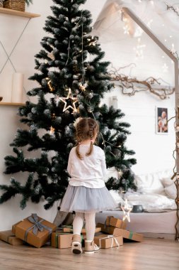 Bir Noel ağacını süsleyen küçük kız bir sırta mal oluyor.