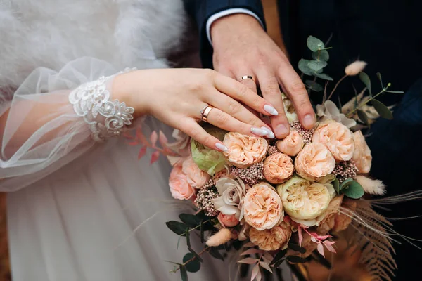 新郎和新娘的手 带着订婚戒指 在婚纱的背景下 — 图库照片