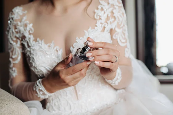 新娘手里拿着一罐香水 漂亮的婚纱 手部特写 结婚的新娘 白色花边裙 漂亮的领带 — 图库照片