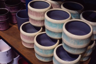 Renkli boş saksılar mağazadaki bir rafta duruyor.