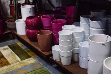 Renkli boş saksılar mağazanın rafında duruyor. Beyaz, pembe, terasotta, kil.