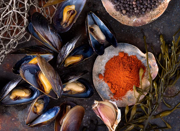 Gedämpfte Miesmuscheln auf rustikalem Hintergrund mit Paprika, Pfeffer, Knoblauch und Algen. — Stockfoto