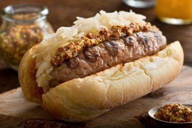 Çörek üzerinde lahana turşusu ile ızgara sosis