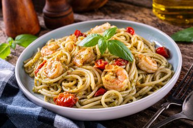 Bir tabak lezzetli karides pesto fesleğen, sarımsak, domates, parmesan, zeytinyağı ve spagetti..