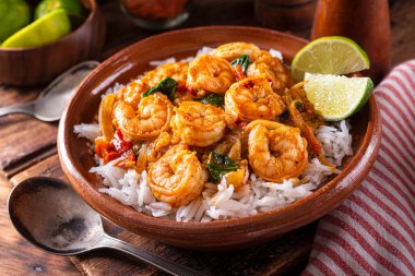 Bir kase lezzetli Hint usulü karides körili masala domates, ıspanak, basmati pilavı ve limonlu.