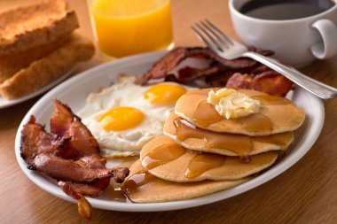 Breakfast with bacon, eggs, pancakes, and toast clipart