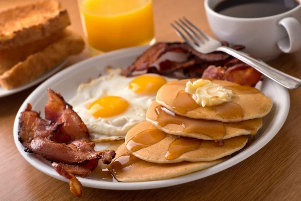 Petit déjeuner avec bacon, œufs, crêpes et pain grillé — Photo