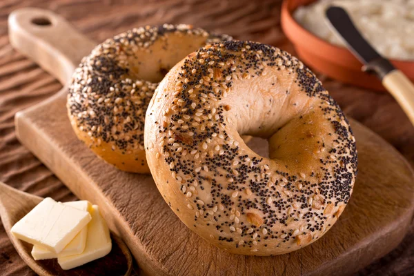 Freshly baked homemade bagels with butter and cream cheese. — Stock Photo, Image